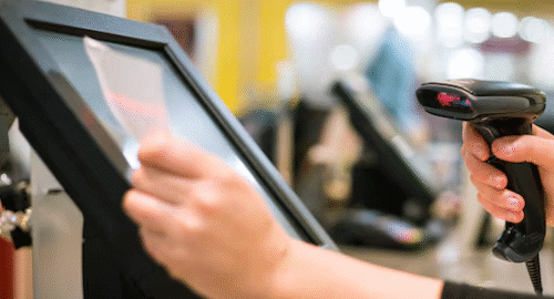 Person using a POS system with a barcode scanner.