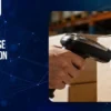Handheld barcode scanner scanning a barcode label on a cardboard box, illustrating warehouse automation solutions for the FMCG industry through automated inventory tracking.