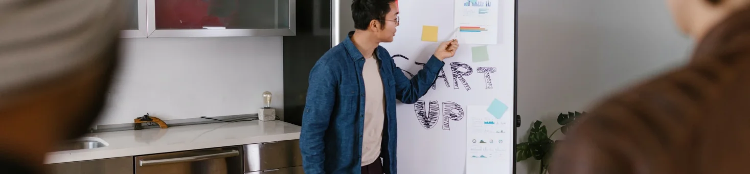 Man In Blue Jacket Looking At White Board